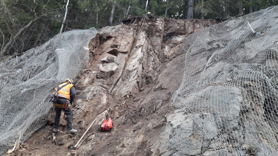 Dělníci pracují na opravě části skalního svahu