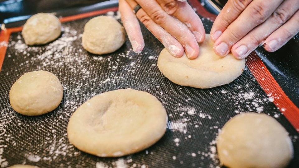 Z bochánků tvarujeme koláče | foto: Jana Volková Z bochánků tvarujeme koláče