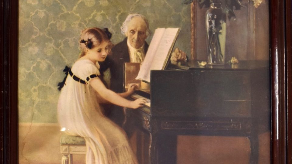 Obraz děvčátka u klavíru s učitelem, dívka má na sobě bílé šaty empirového střihu
