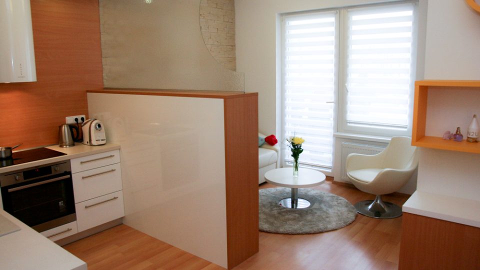 Nižší skříňka a prosklená stěna decentně vytvoří obývací část