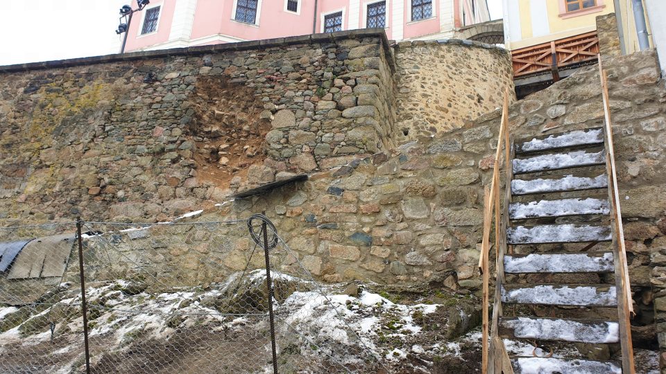 Jedna z přilehlých kamenných zdí je vážně poškozená